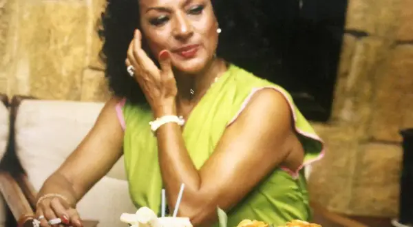 Lola Flores, icónica artista, sonríe con un cigarrillo en la mano. Su fecha de nacimiento es un misterio para muchos, pero su legado es eterno.