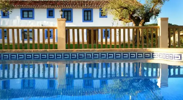 El cortijo Los Pradillos, con su piscina azul y reflejos, invita a un descanso bajo el sol andaluz.