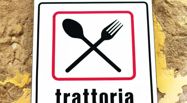 Segnale con forchetta e cucchiaio incrociati, che indica una trattoria. Un invito a gustare sapori autentici, diverso dall'osteria.