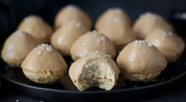 Små, karamellglaserade biskvier med flingsalt, ett läckert biskvier recept. En är uppäten och visar det fluffiga inkråmet.