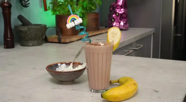 Leckeres protein shake rezept mit Banane und einer Prise Kakao. Dazu eine Schüssel mit Quark.