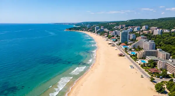 Bułgaria, sierpień: słoneczna plaża z hotelami i turkusowym morzem. Idealna pogoda na wakacje.