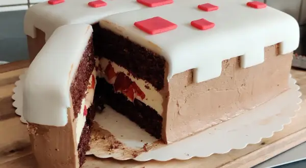 En chokladtårta med vit marsipan och röda dekorationer, inspirerad av Minecraft. Perfekt för ett Minecraft tårta recept!