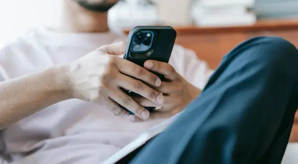 Mężczyzna z telefonem w dłoniach. Zastanawia się, jak sprawdzić czy ktoś mnie zablokował na Messengerze.
