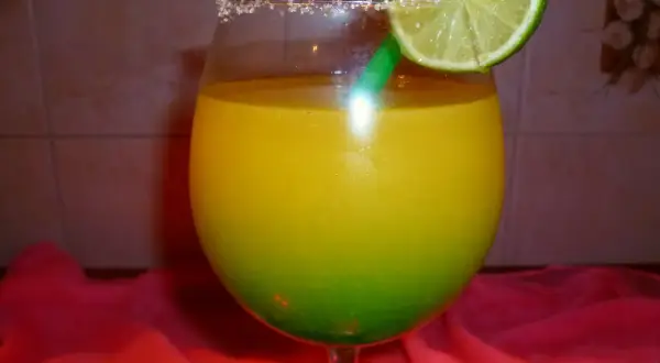 Orzeźwiający drink z Żabki, z zieloną słomką i plasterkiem limonki, ozdobiony cukrowym rantem.