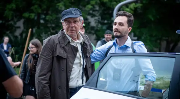 Stars serialu "Dzielnica strachu" obsada: starszy mężczyzna w czapce i płaszczu oraz młodszy w niebieskiej koszuli przy radiowozie.