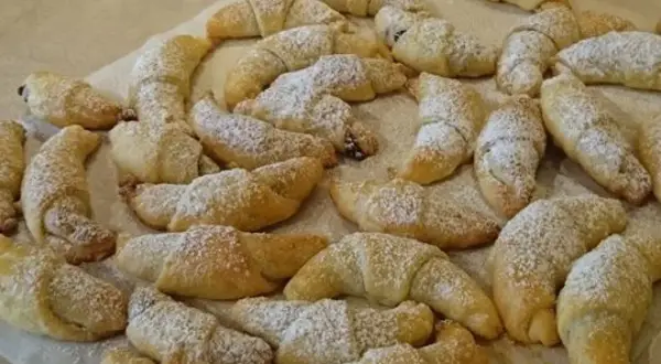 Mnóstwo pysznych, domowych rogalików z powidłami, posypanych cukrem pudrem. Idealne na deser lub do kawy.