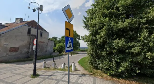 Znak pierwszeństwo łamane kierunkowskaz informuje o skręcie w prawo i ustąpieniu pierwszeństwa. Obok znak przejścia dla pieszych.