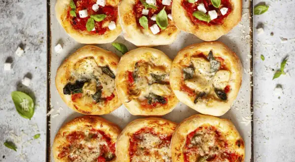 Gotowe ciasto na pizzę w różnych wariantach: z fetą i bazylią, z karczochami i szpinakiem, oraz z warzywami.