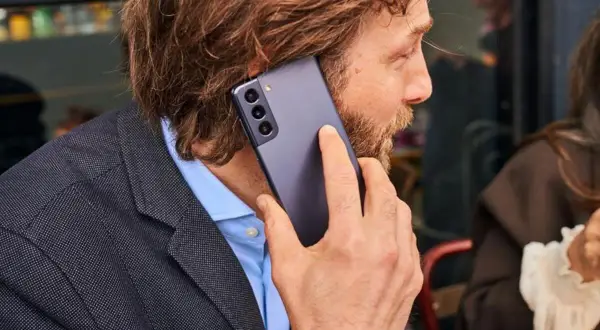 Mężczyzna rozmawia przez telefon, a komunikat "brak pamięci w telefonie" pojawia się na ekranie.