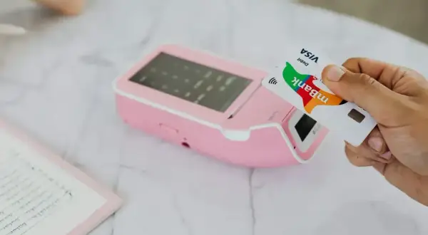 Zbliżenie na kartę płatniczą zbliżaną do terminala. Warto wiedzieć, czy w Pradze można płacić euro, bo karta mBank Visa Debit jest gotowa do transakcji.