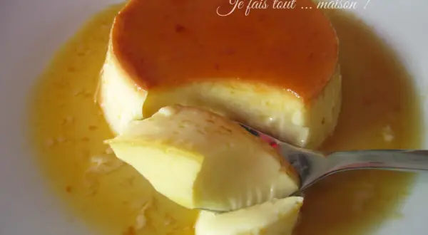 Une cuillère prélève un morceau d'un délicieux crème renversée maison, baignant dans son caramel doré.