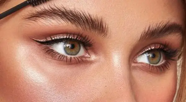 Cepillo peinando unas cejas perfectas para un laminado de cejas impecable.