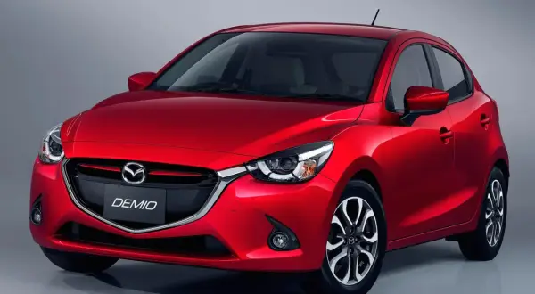 Czerwona Mazda Demio z eleganckim przodem i charakterystycznym grillem.