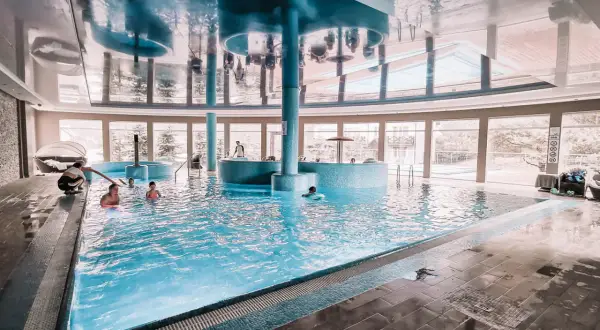 Relaks w basenie hotelu Tristan. Dzieci pluskają się w wodzie, a dorośli odpoczywają przy basenie.