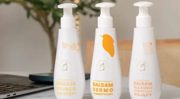 Emolienty co to? Trzy białe butelki z pompką: emulsja myjąca, balsam dermo i balsam kojący dla dzieci.