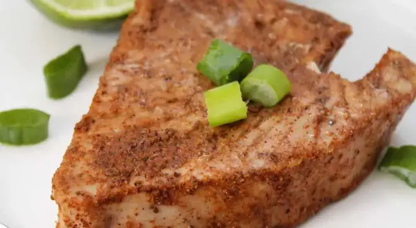 En saftig bit tonfisk, kryddad och perfekt tillagad. Serverad med lime och salladslök för en fräsch touch.