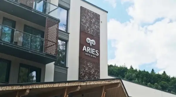 Nowoczesny hotel Aries w Szczyrku z ozdobnymi panelami i widokiem na las.