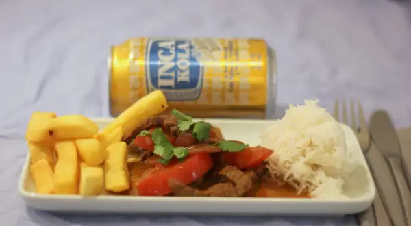 Lomo Saltado mit Pommes, Reis und Inca Kola. Ein herzhaftes Gericht, das den Gaumen erfreut.