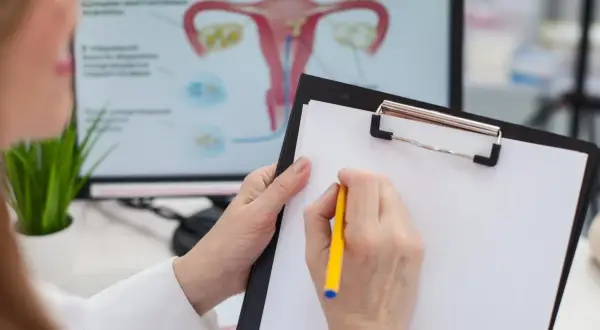 Lekarz omawia z pacjentką, co to cytologia, analizując wyniki na ekranie z anatomią układu rozrodczego.