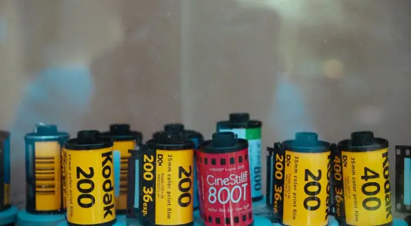 A collection of various types of 35mm film rolls, including Kodak 200, Kodak 400, and CineStill 800T, are displayed.