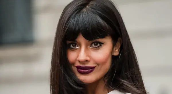 Frau mit stufig langen Haaren mit Pony, dunklem Lippenstift und auffälligem Augen-Make-up.