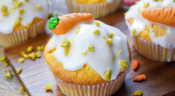 Leckere, schnelle Muffins mit weißer Glasur und kleinen Marzipan-Karotten. Perfekt für den Osterbrunch!
