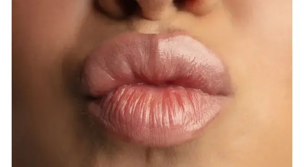 Labbra carnose e lucide, un primo piano che mostra come rimpolpare le labbra per un effetto voluminoso e sensuale.
