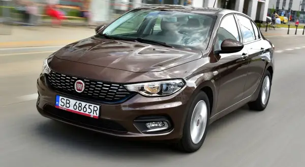 Brązowy fiat tipo sedan w ruchu miejskim.