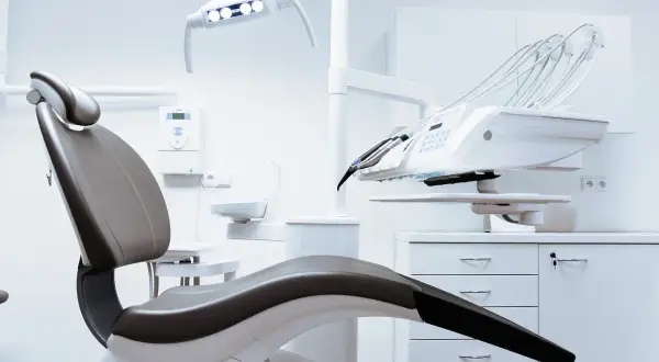 Nowoczesny gabinet stomatologiczny z fotelem i aparaturą. Czas na pytania: ile trwa leczenie ortodontyczne?