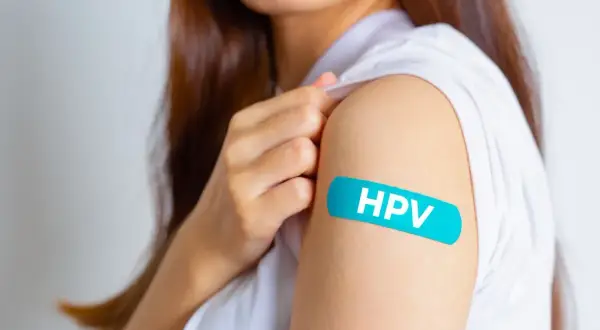 Ramię z plastrem z napisem HPV. Dostępność szczepionki HPV i refundacja to ważna kwestia dla zdrowia.