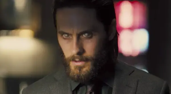 Jared Leto w filmach, z bladymi oczami i brodą, w garniturze.