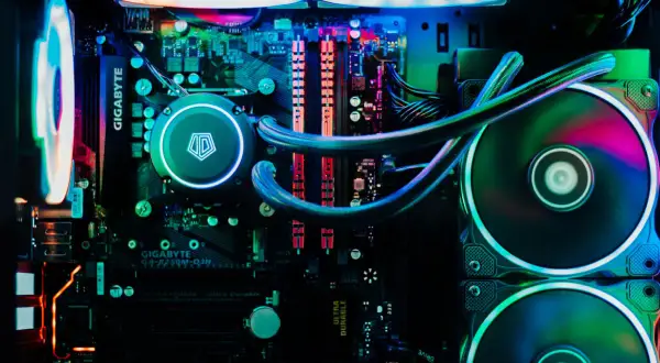 Wnętrze komputera z podświetleniem RGB. Widoczny system chłodzenia wodnego i wentylatory, które zapewniają efektywne chłodzenie.