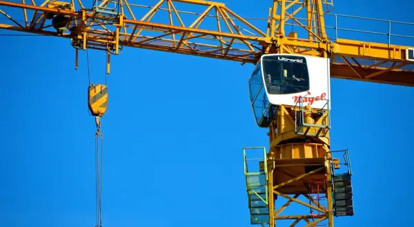 Żuraw budowlany z kabiną operatora. Taki widok może być częścią dokumentacji ZUS wykaz stanowisk pracy w szczególnych warunkach.