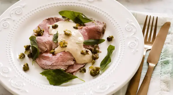 Skivor av tunt skuret kött toppas med en krämig tonfisksås, kapris och salviablad. En elegant portion av vitello tonnato.