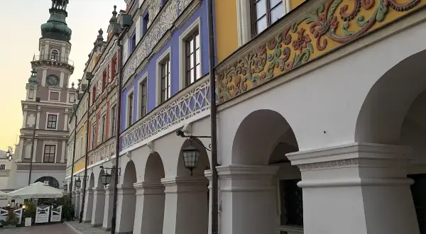 Zamość co zobaczyć: kolorowe kamienice z arkadami i wieża ratuszowa tworzą malowniczy widok.