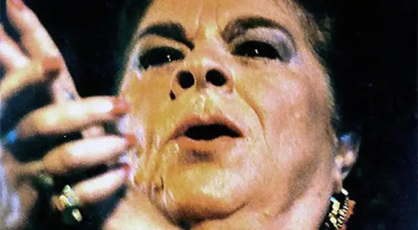 Primer plano de una mujer con maquillaje dramático, labios entreabiertos y mano levantada. Se especula de que murió la Paquera de Jerez.