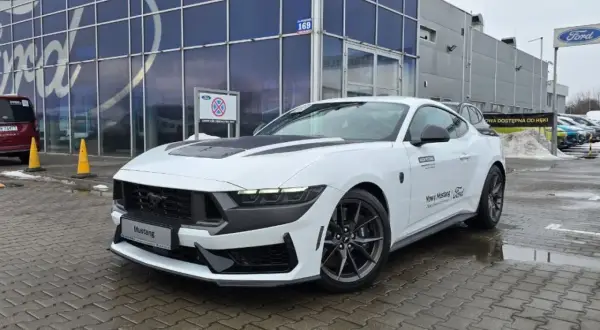 Biały Ford Mustang przed salonem Ford. Sprawdź aktualną mustang cena i dostępność od ręki.