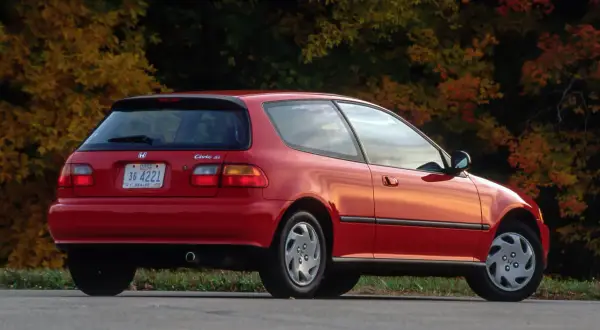 Czerwony Honda Civic Si z lat 90. na tle jesiennych drzew.