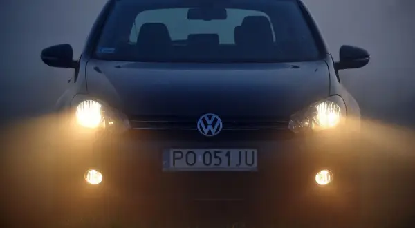 Volkswagen z włączonymi światłami przeciwmgielnymi przednimi, gotowy do jazdy w mgle.