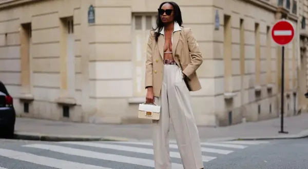 Eine Frau in beiger Marlenehose und Blazer, die einen stilvollen Look kreiert.