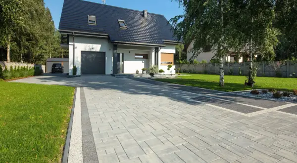Nowoczesny dom z garażem i pięknym podjazdem z kostki granitowej.