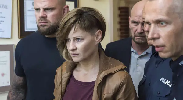 Małgorzata Kożuchowska w filmach często wciela się w silne kobiety. Tutaj w otoczeniu policji, w scenie pełnej napięcia.