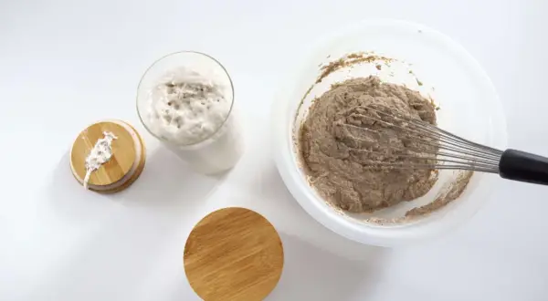 Masa madre burbujeante y masa para pan en un bol con varillas. Preparando pan masa madre.