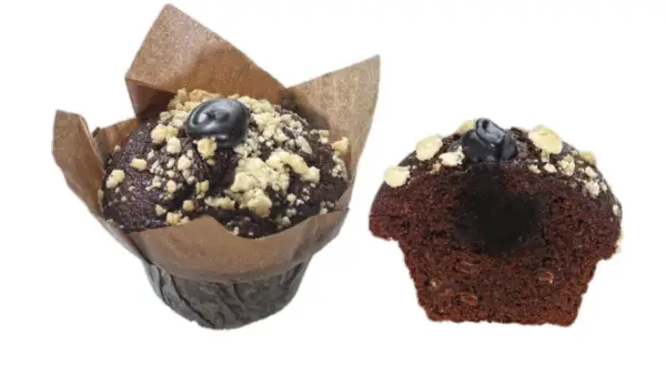 Zwei saftige triple chocolate muffins, einer im Papierförmchen, der andere angeschnitten, mit Schokostückchen und Streuseln.