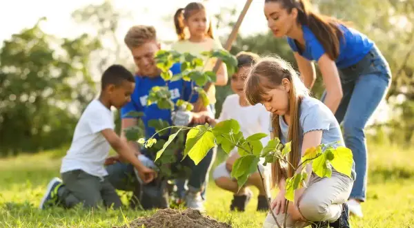 Kinder pflanzen Bäume im Rahmen eines Projekts zum Umweltschutz im Kindergarten.