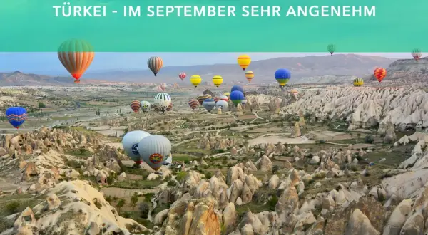 Heißluftballons steigen über die Felsformationen von Kappadokien auf. Perfekt für Backpacking im September.