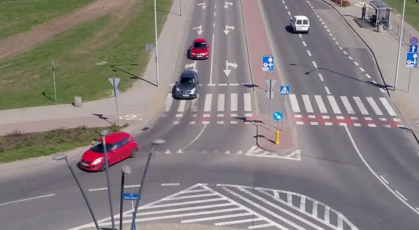 Samochody poruszają się po skrzyżowaniu z wyznaczonymi pasami ruchu, które przypominają rondo turbinowe.