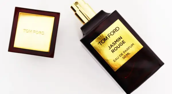 Elegancka butelka perfum Tom Ford Jasmin Rouge z złotą etykietą i korkiem.