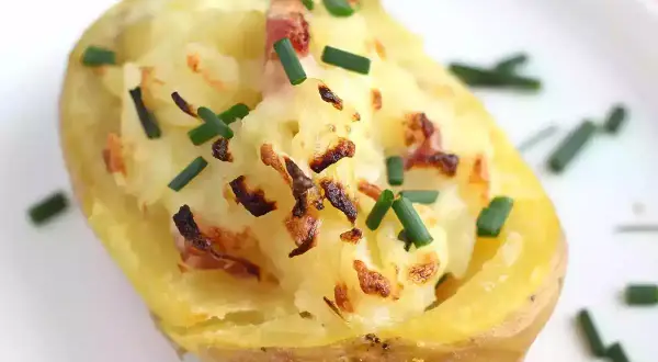 Patatas al horno con queso y bacon, gratinadas y espolvoreadas con cebollino fresco. ¡Un bocado delicioso!